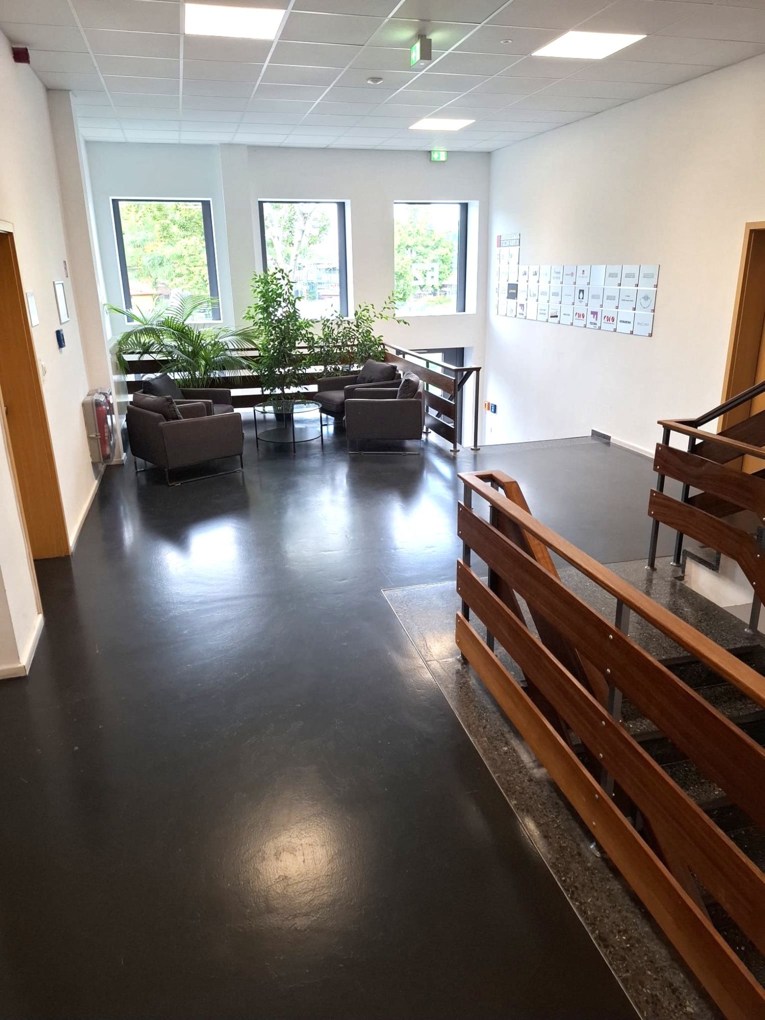 Foyer mit Sitzecke, Pflanzen und Mieterübersicht in der Tuchfabrik